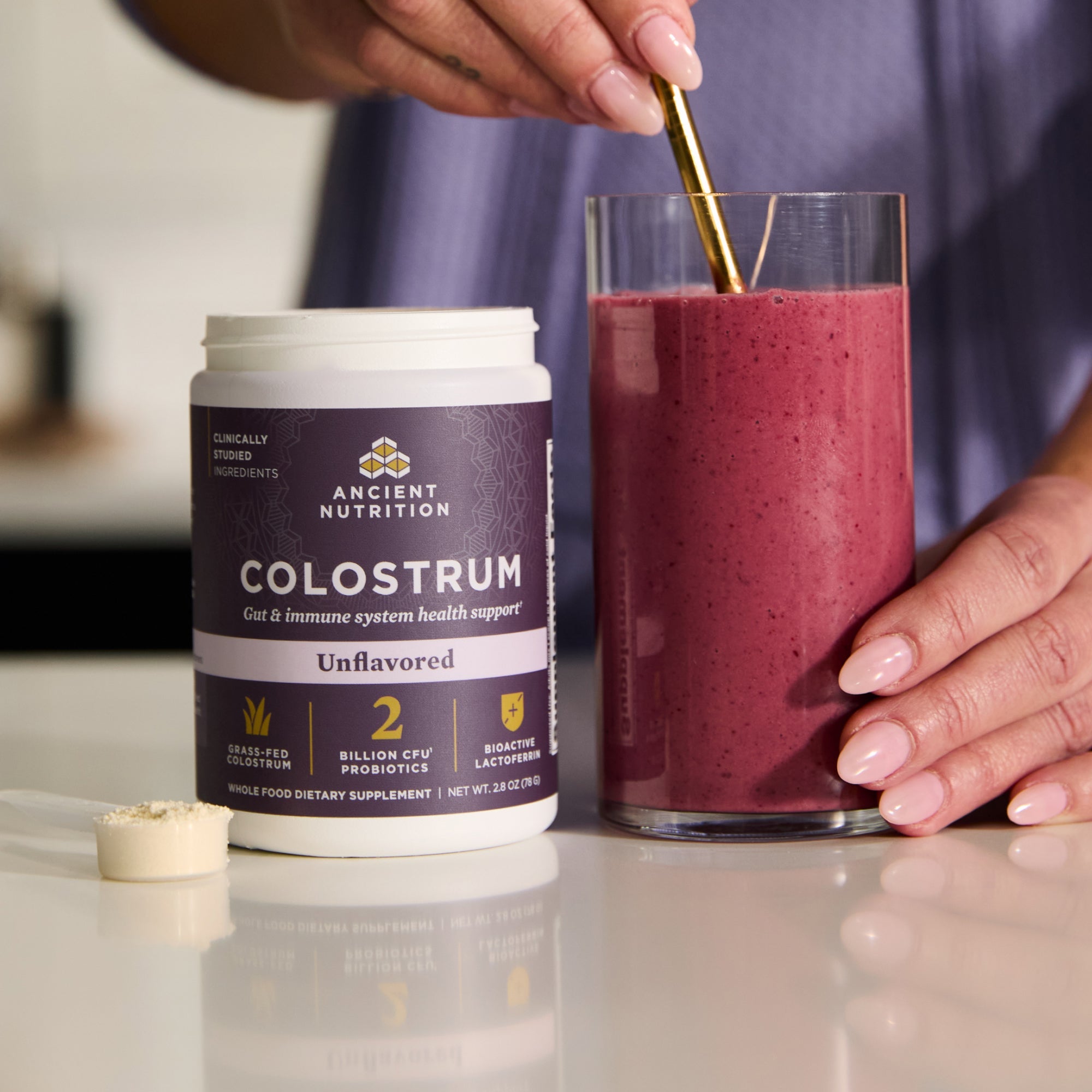 a bottle of Colostrum Powder Unflavored (60 Servings) next to a smoothie