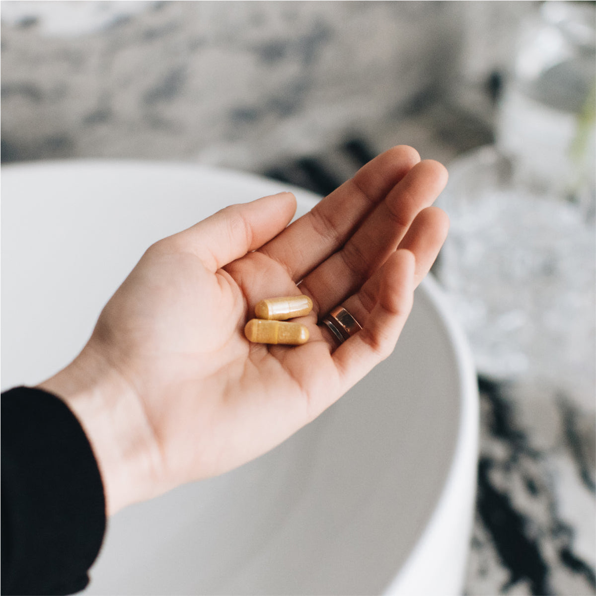 a person putting multi collagen capsules joint + mobility in their hand