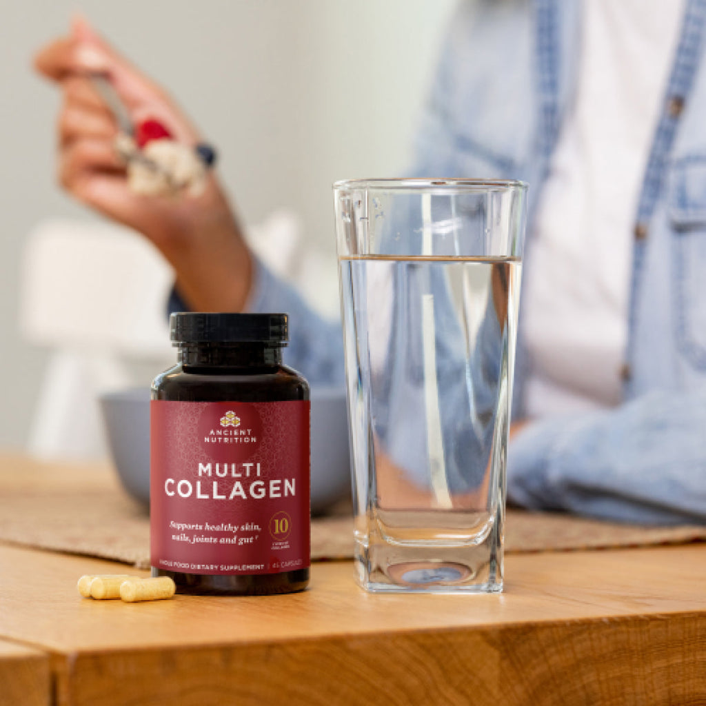a bottle of Multi Collagen Capsules (45 Capsules) next to a glass of water