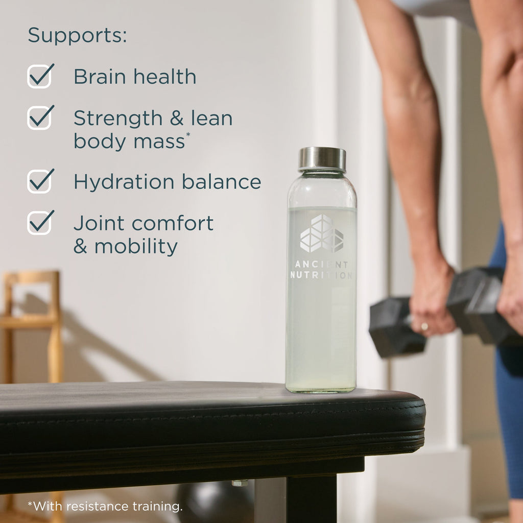 Clear bottle with a logo on a table, person holding dumbbells in the background, text about product benefits.