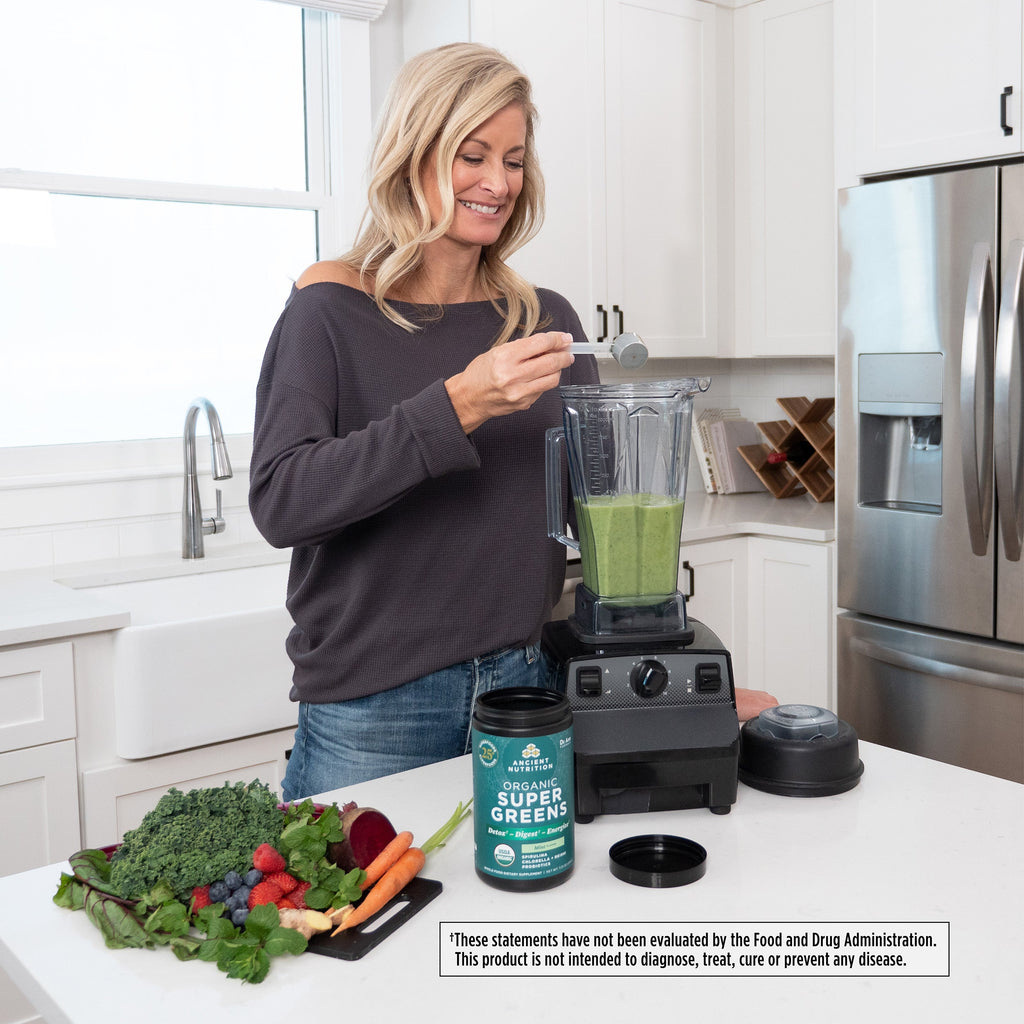 a woman making a green smoothie
