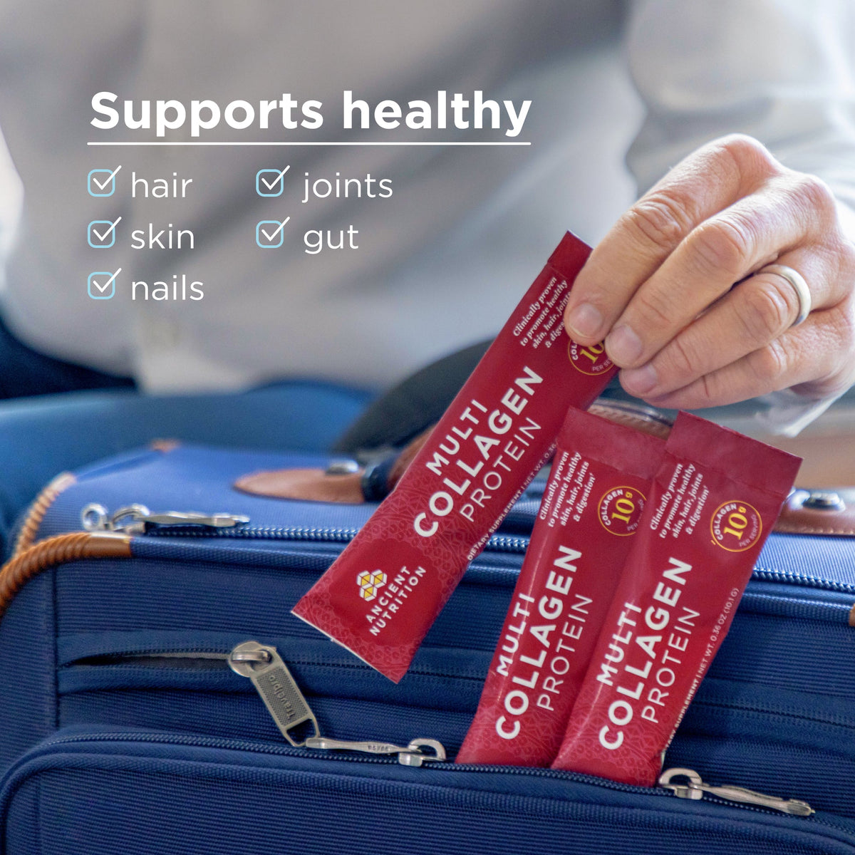 Hand holding red Multi Collagen Protein packets with text about health benefits on a blurred background.