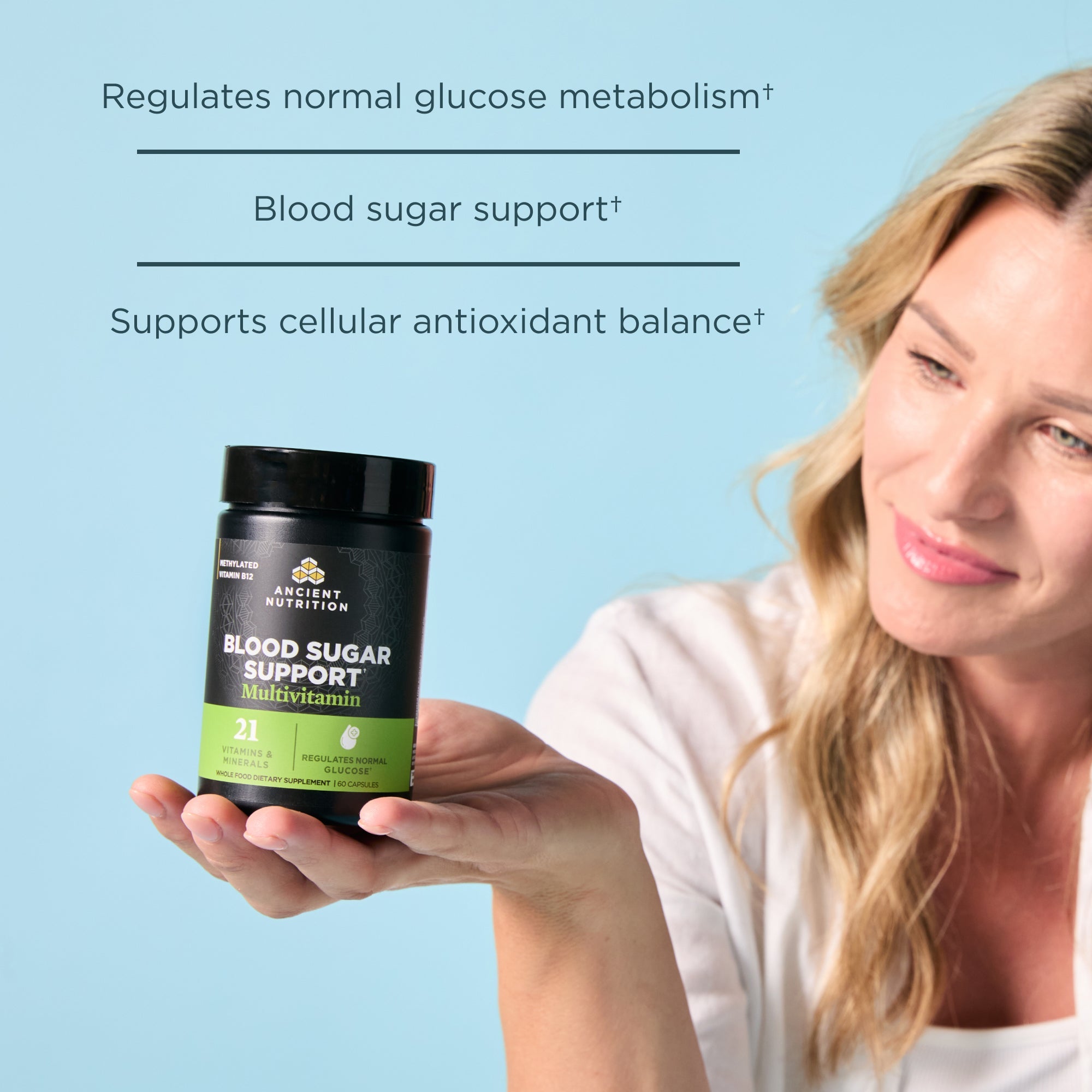 Person holding a supplement bottle labeled 'Blood Sugar Support' with text about its benefits on a light blue background.
