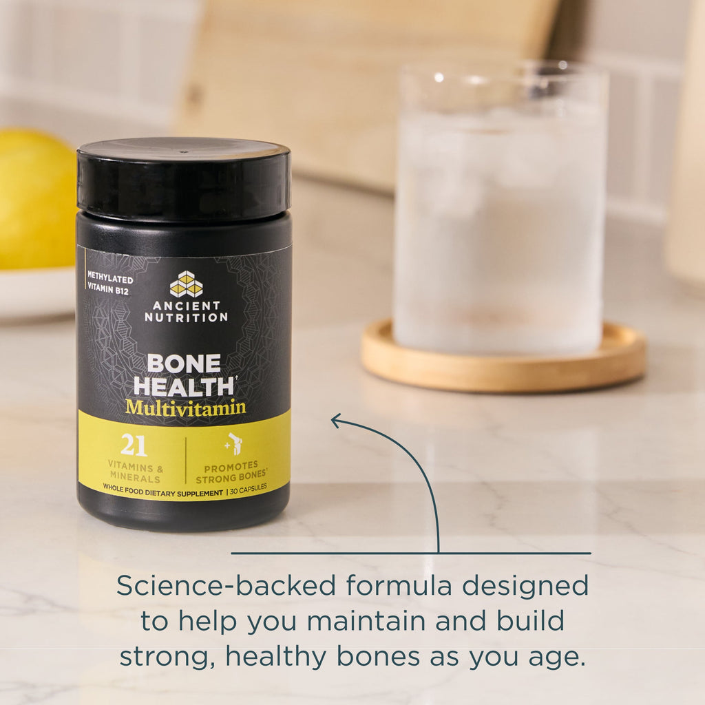 Ancient Nutrition Bone Health Multivitamin bottle on a table with text about bone health.