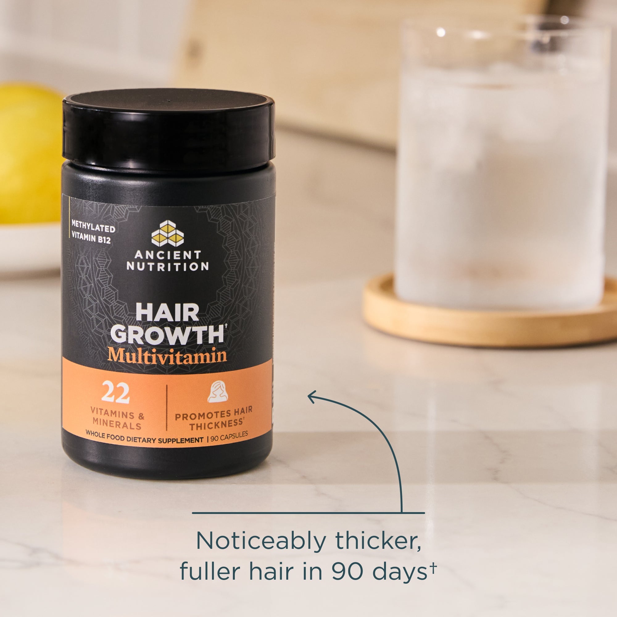 Ancient Nutrition Hair Growth Multivitamin container on a countertop with text about hair thickness and growth.