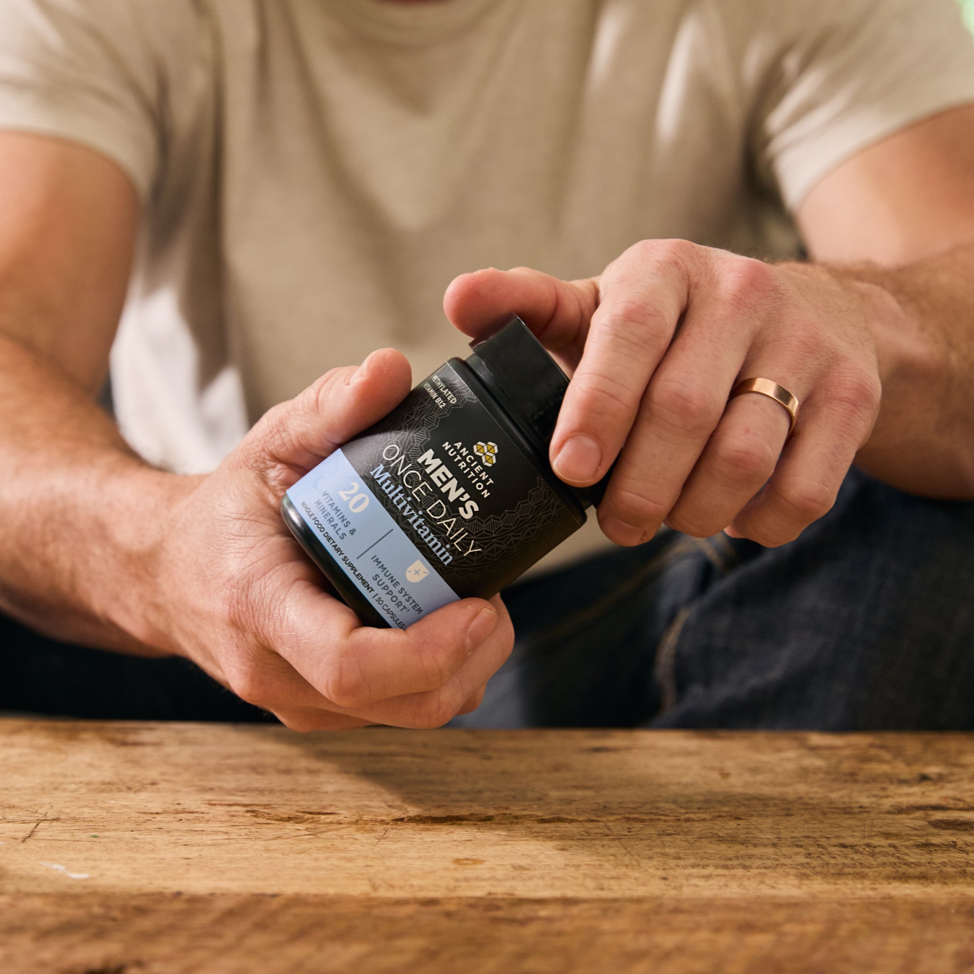a person holding a bottle of Ancient Multivitamin Men's Once Daily Capsules (30 Capsules) in their hand