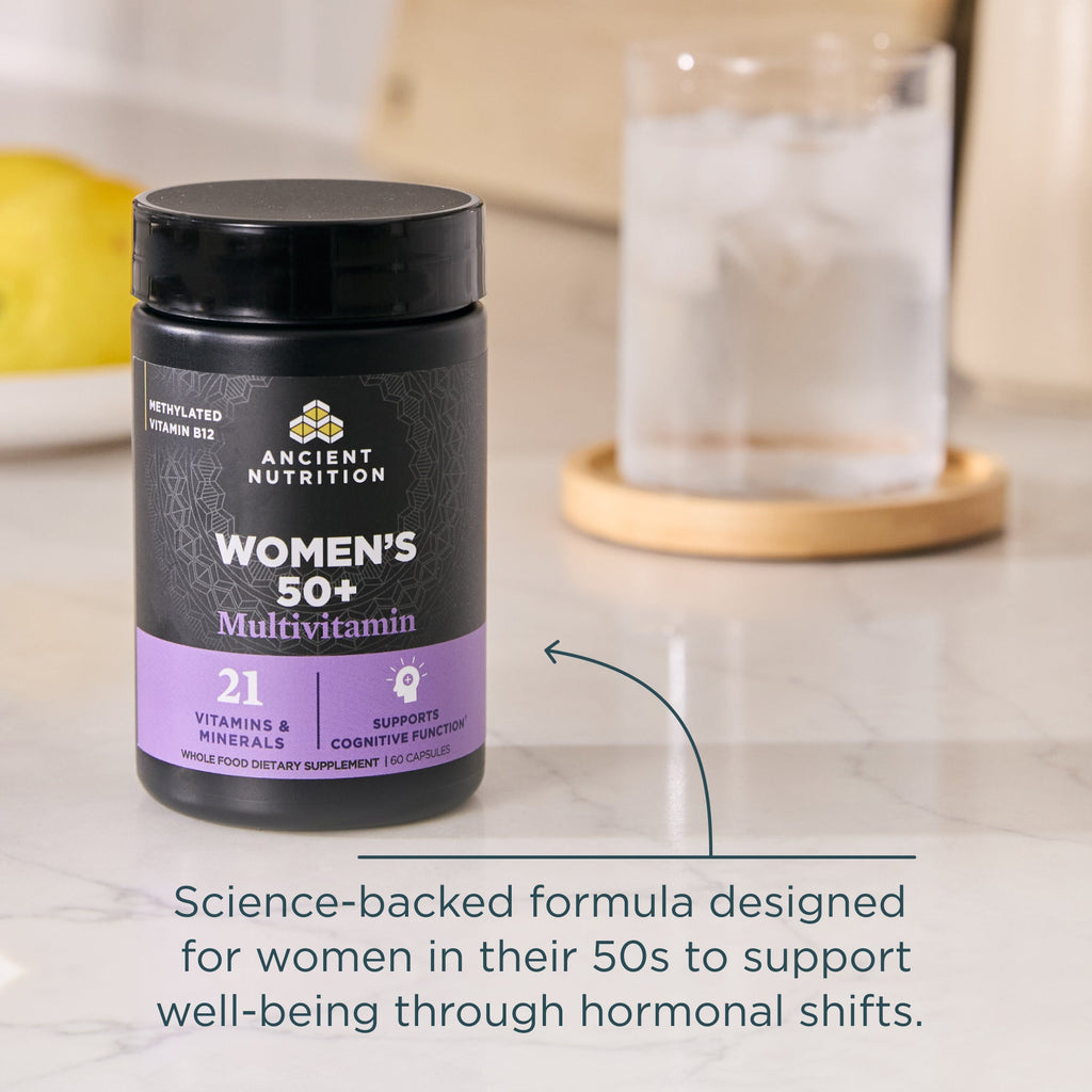 Multivitamin supplement bottle for women over 50 on a kitchen counter.