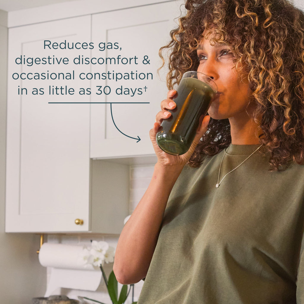 Woman drinking from a glass with text about digestive benefits in a kitchen setting