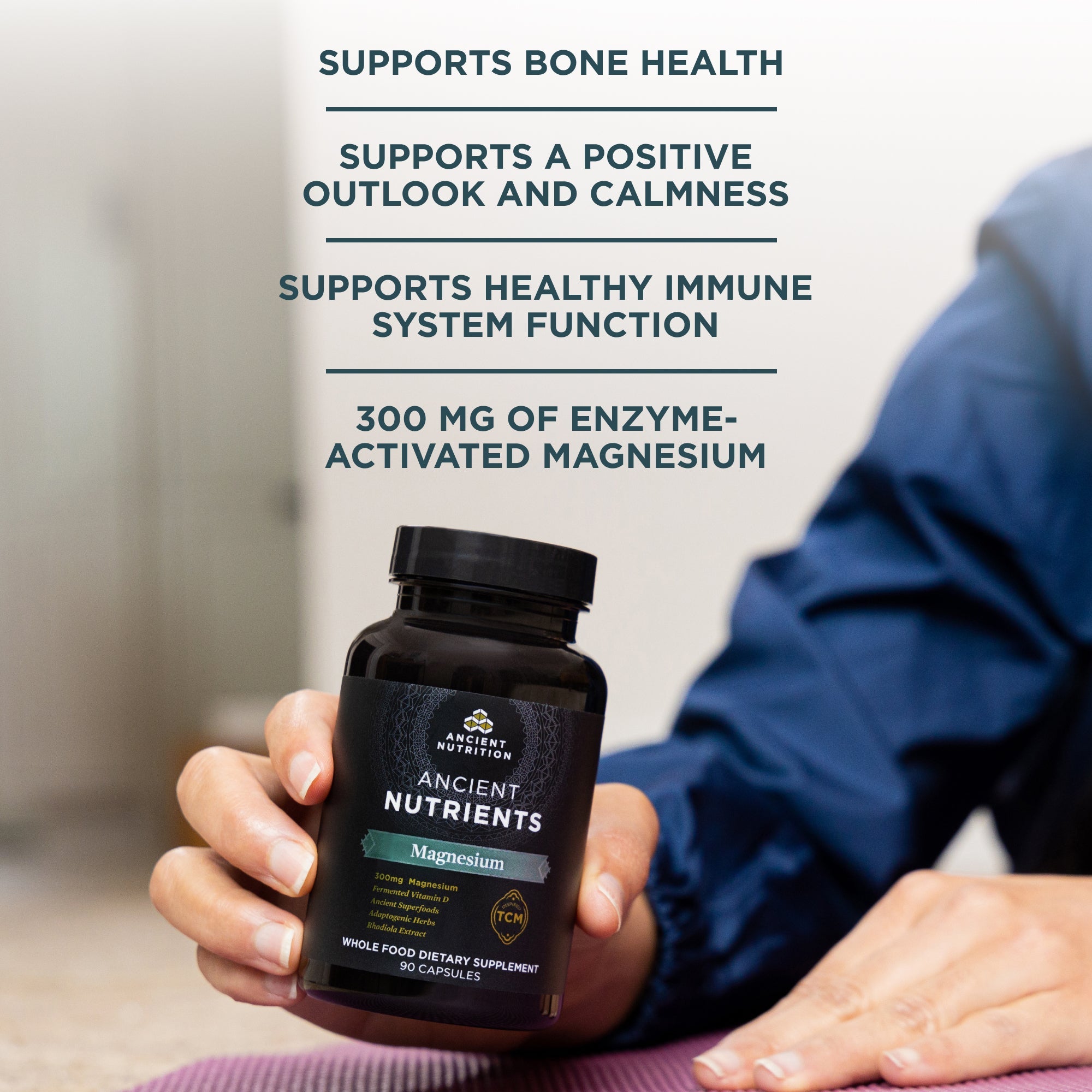 a bottle of Ancient Nutrients Magnesium Capsules (30 Servings) in someones hand with product benefits