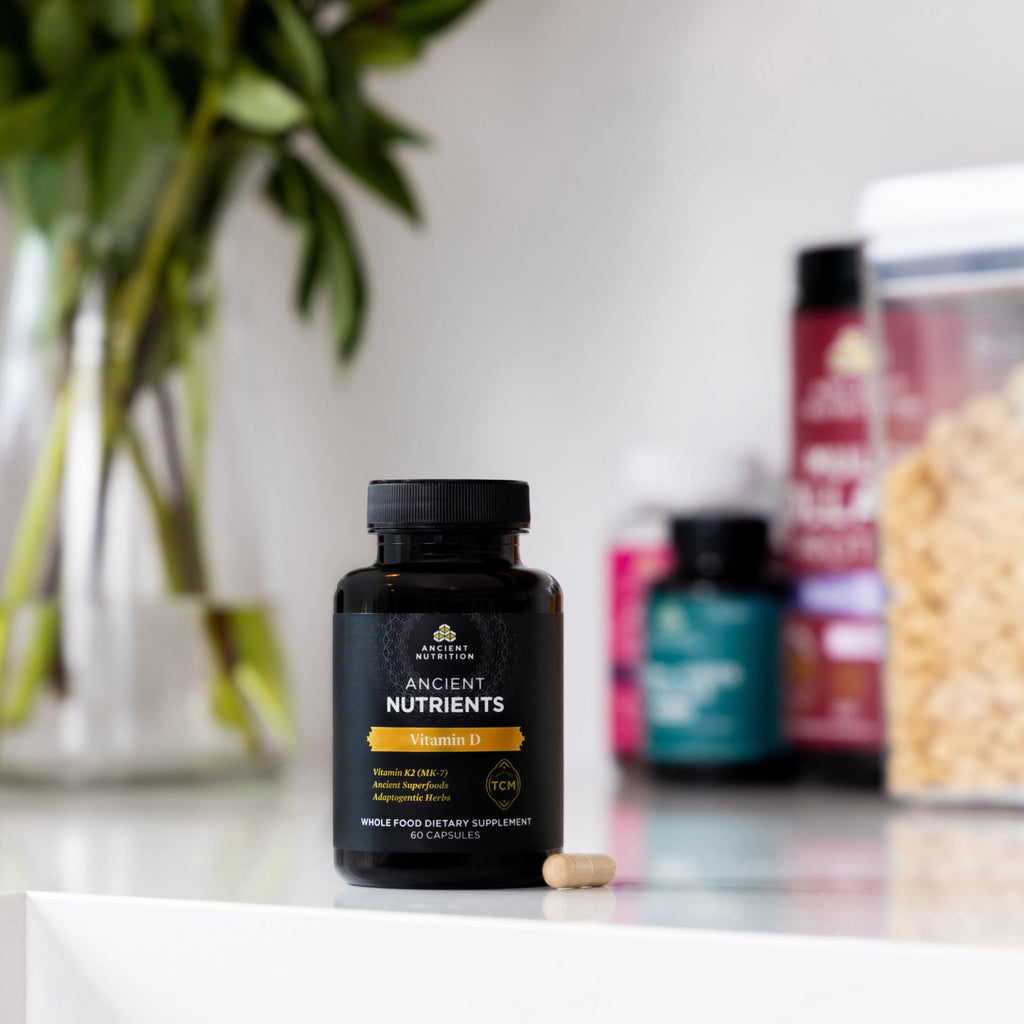 Ancient Nutrients Vitamin D3 + K2 Capsules bottle on a counter with other supplements in the background