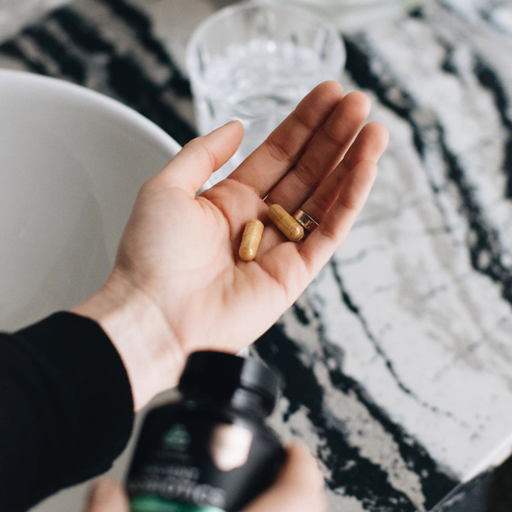woman with capsules in hand