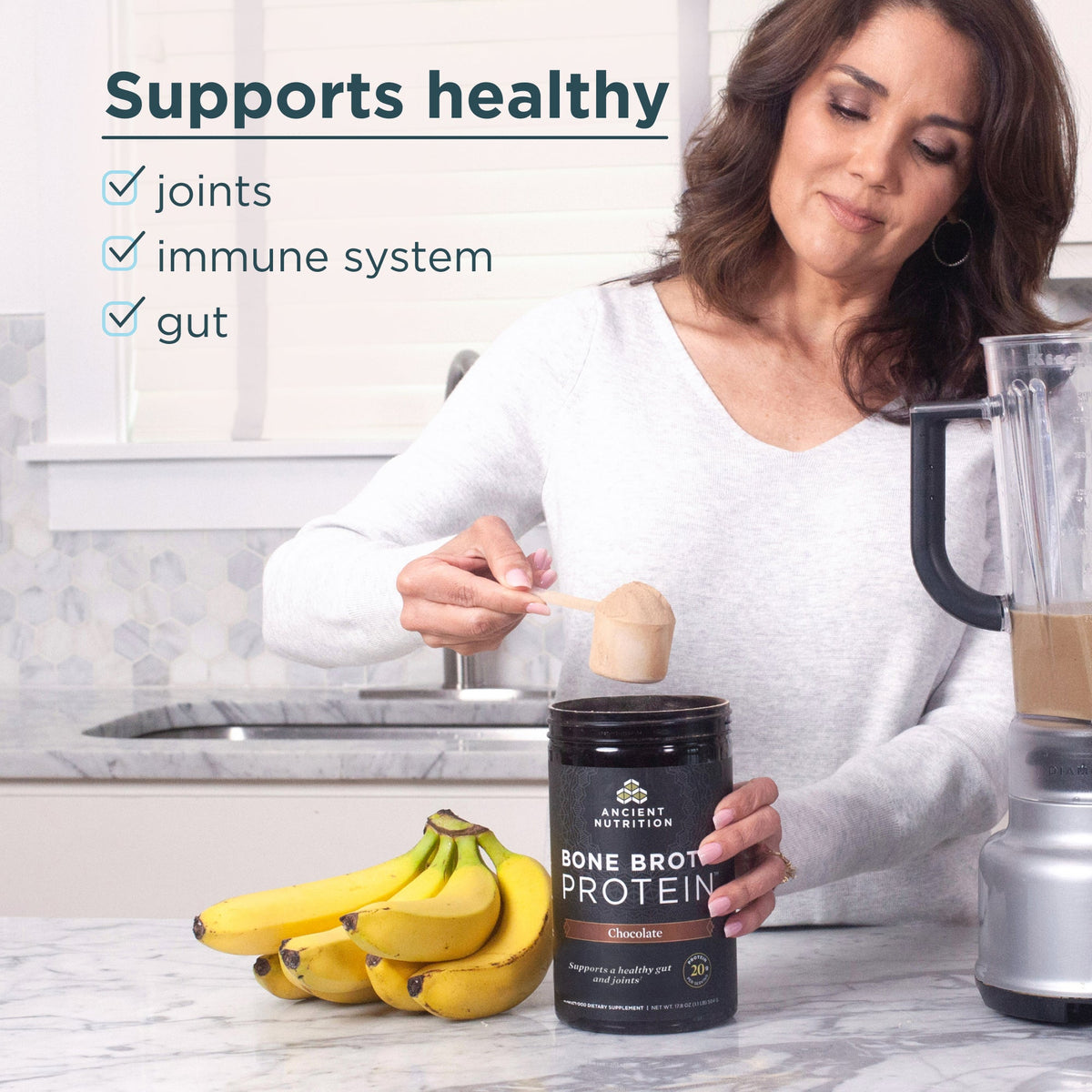 a woman taking a scoop of bone broth protein out of the container