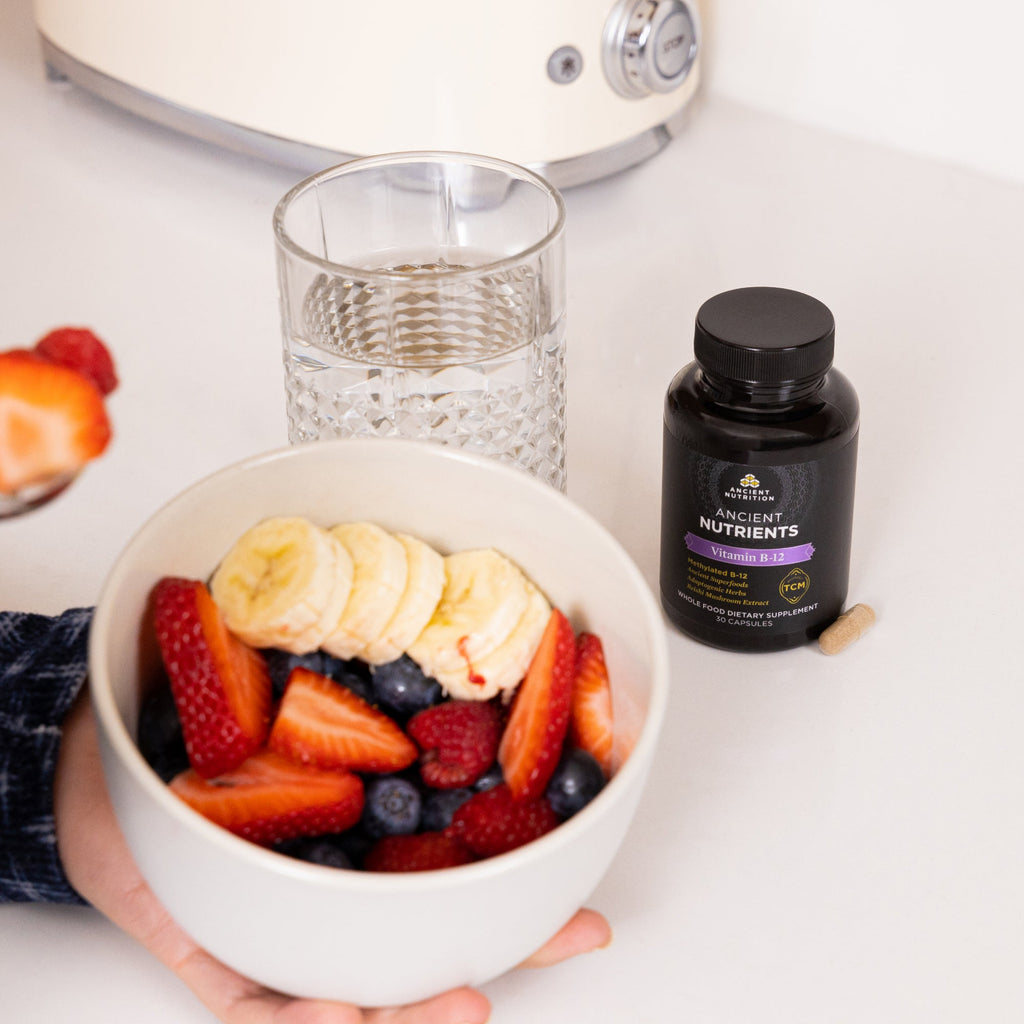 bottle of vitamin B12 next to a bowl of fruit