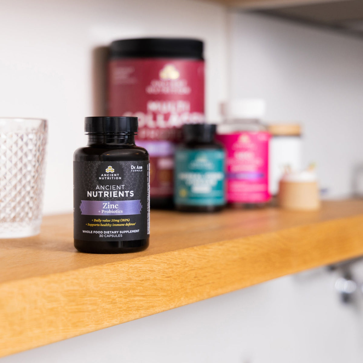 a bottle of Ancient Nutrients Zinc + Probiotics Capsules on a shelf with other supplement bottles