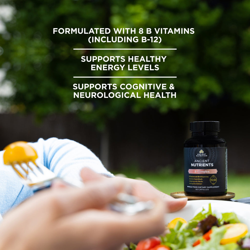 Ancient Nutrients Vitamin B Complex Capsules (30 Servings) bottle next to a person eating a salad
