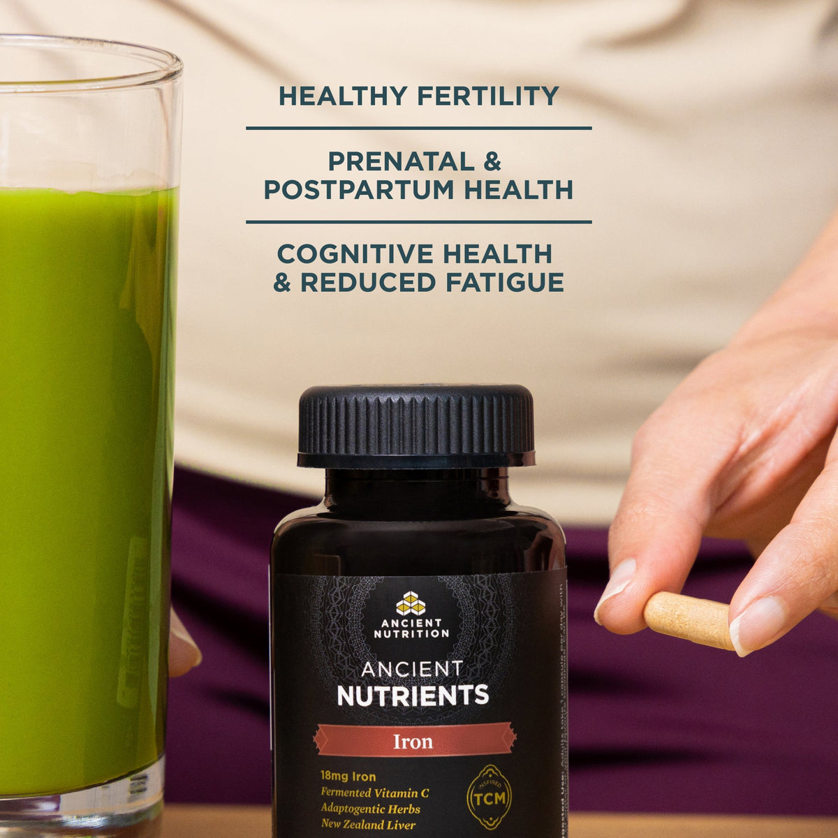 a bottle of Ancient Nutrients Iron Capsules (30 Capsules) next to a glass of green juice
