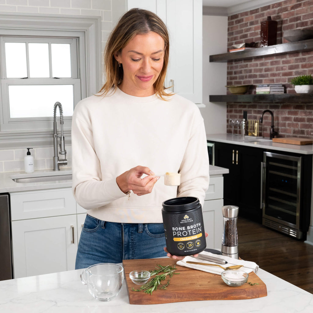woman scooping bone broth protein chicken soup