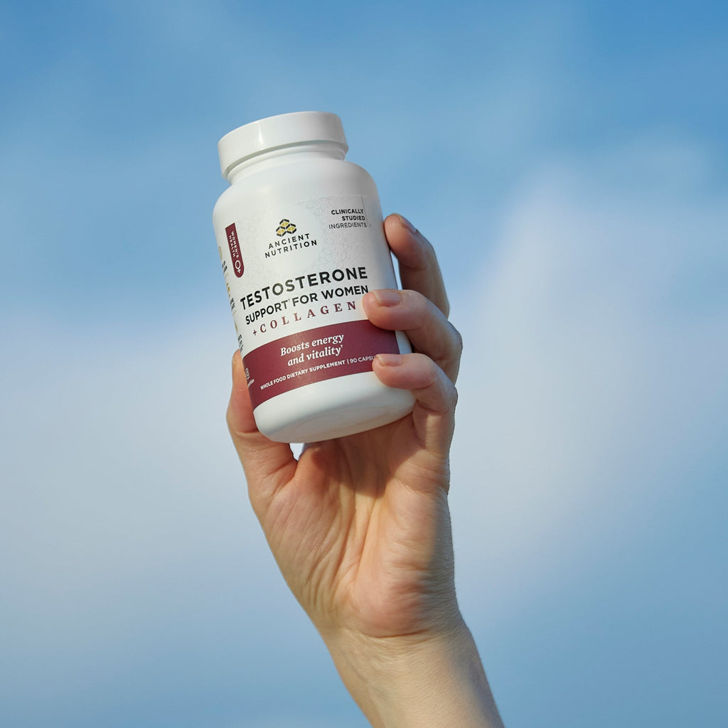a bottle of Testosterone Support for Women + Collagen Capsules in the air