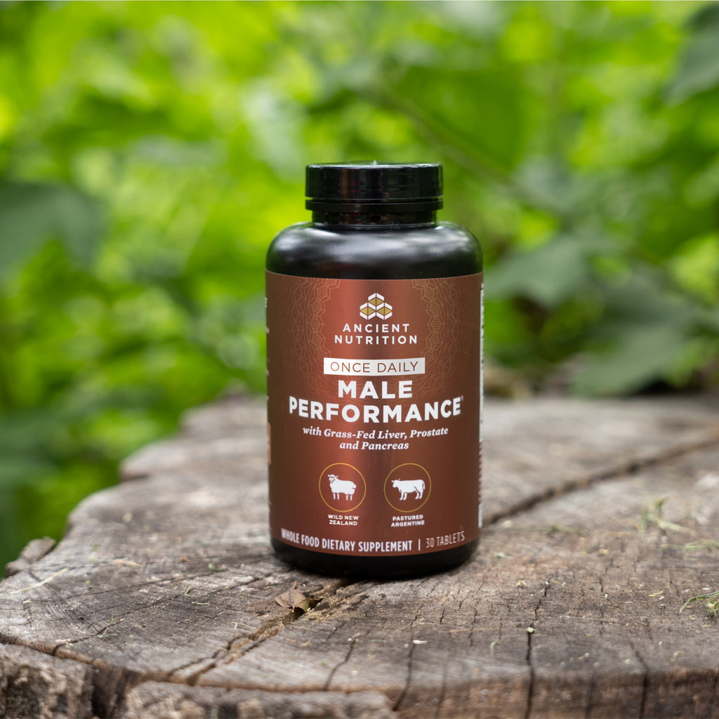 a bottle of Male Performance Once Daily Tablets on a tree stump