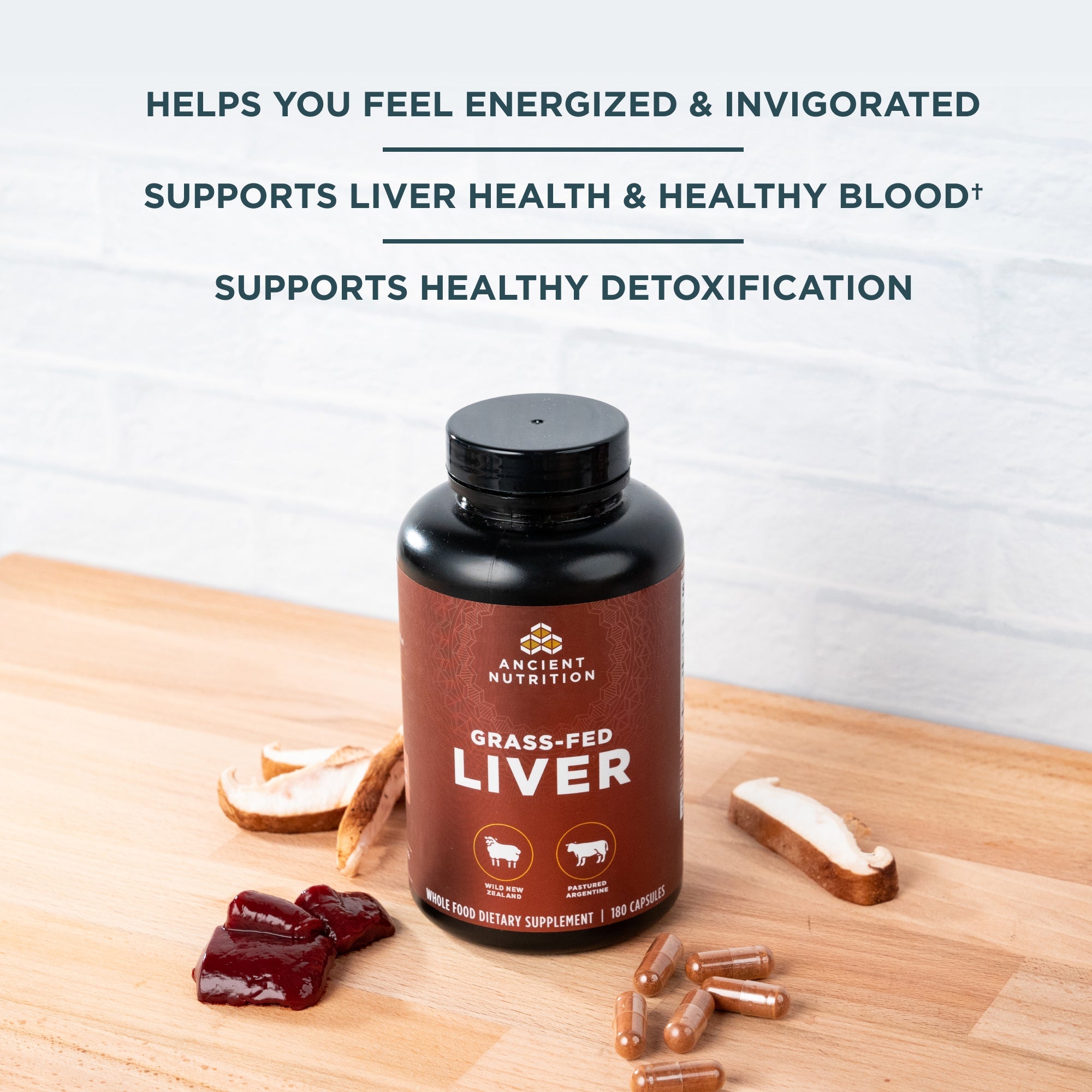 a bottle of Grass-Fed Liver Capsules with mushrooms, liver and capsules surrounding it