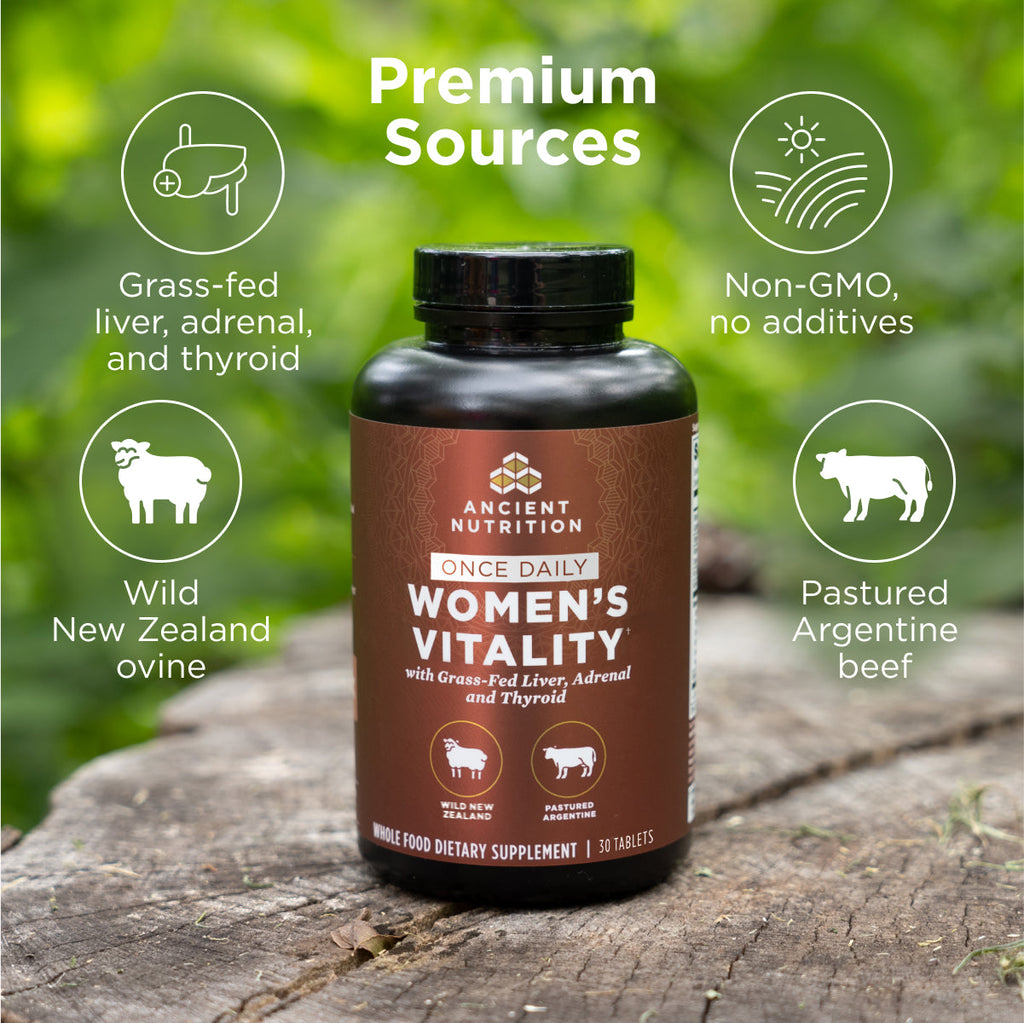 a bottle of Women's Vitality Once Daily Tablets on a tree stump with text that says Premium Sources