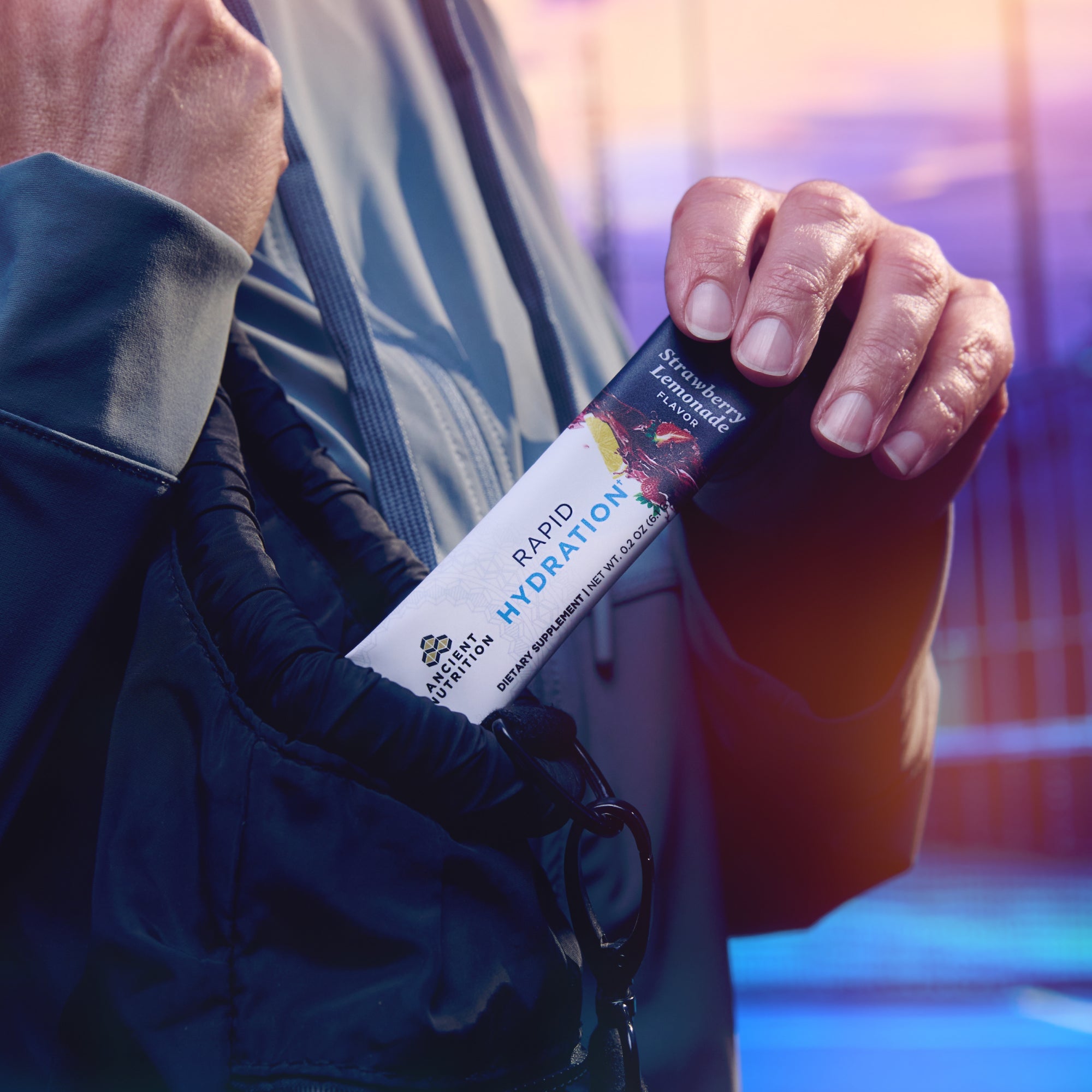 a person grabbing a Rapid Hydration Powder Strawberry Lemonade Flavor  stick pack