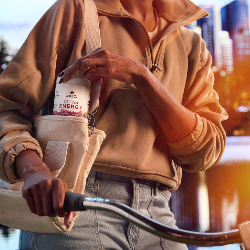 a person with a bottle of Clean Energy Powder Strawberry Kiwi Flavor (30 Servings) bottle in a purse