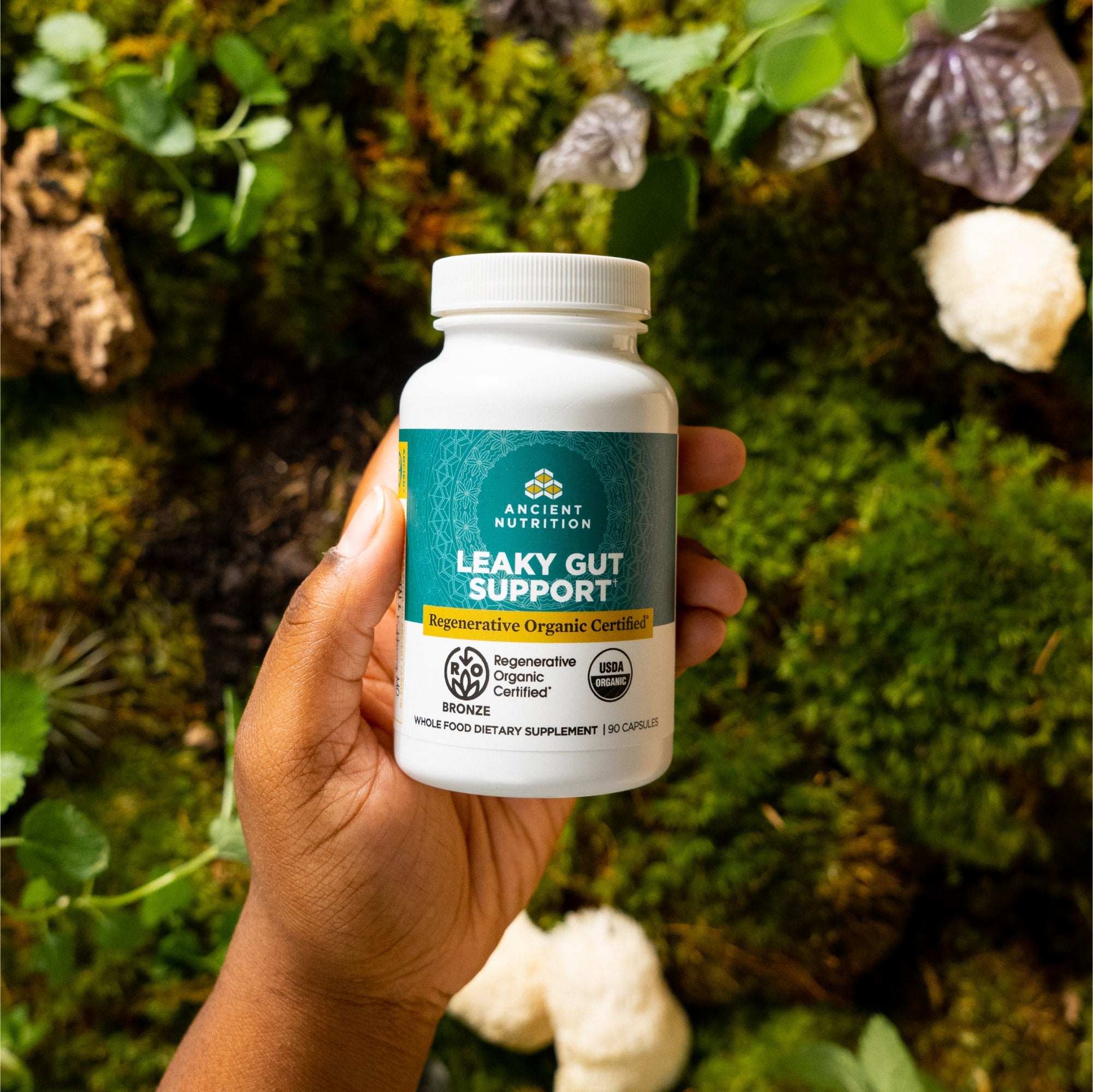 a person holding a bottle of Regenerative Organic Certifiedª Leaky Gut Support