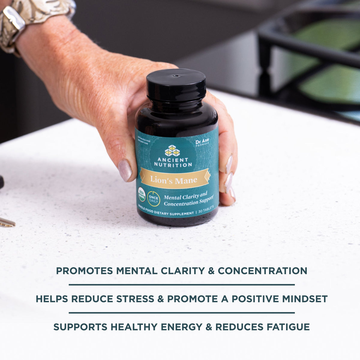 a person holding a bottle of Lion's Mane Mental Clarity and Concentration Tablets on a counter