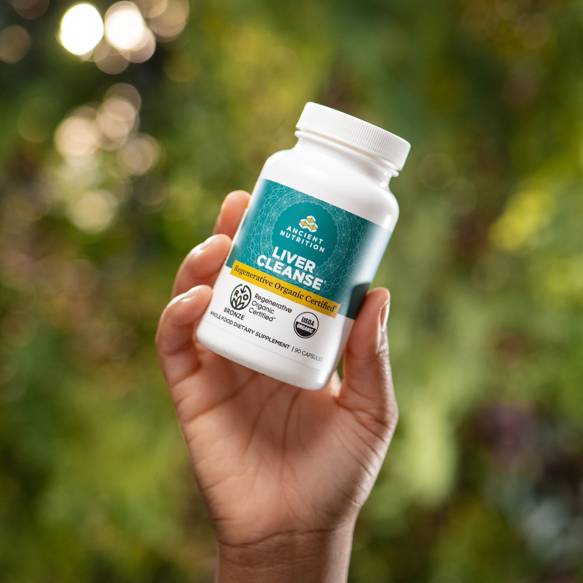 a person holding a bottle of Regenerative Organic Certifiedª Liver Cleanse