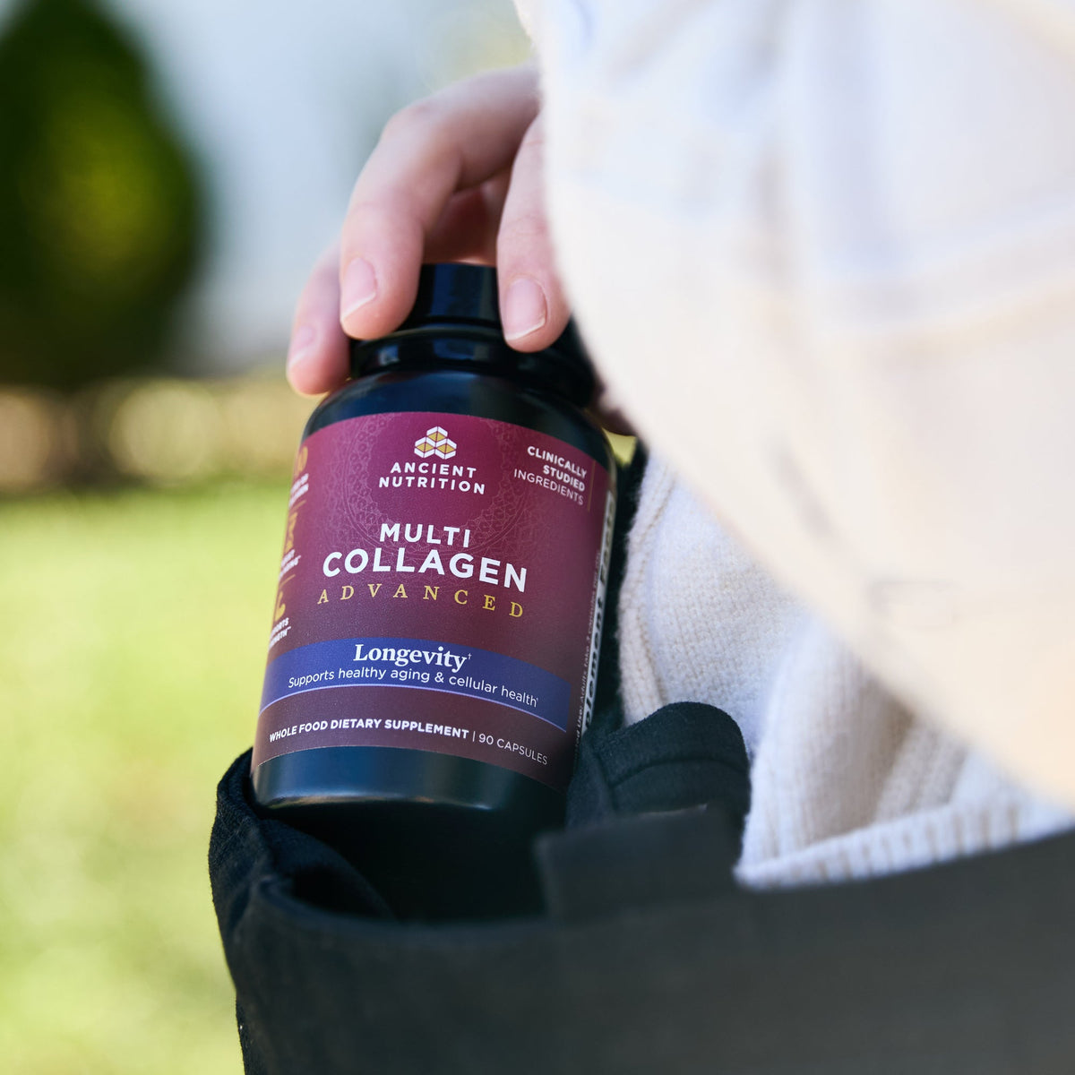 a bottle of Multi Collagen Advanced Longevity† Capsules (30 Servings) coming out of someones bag
