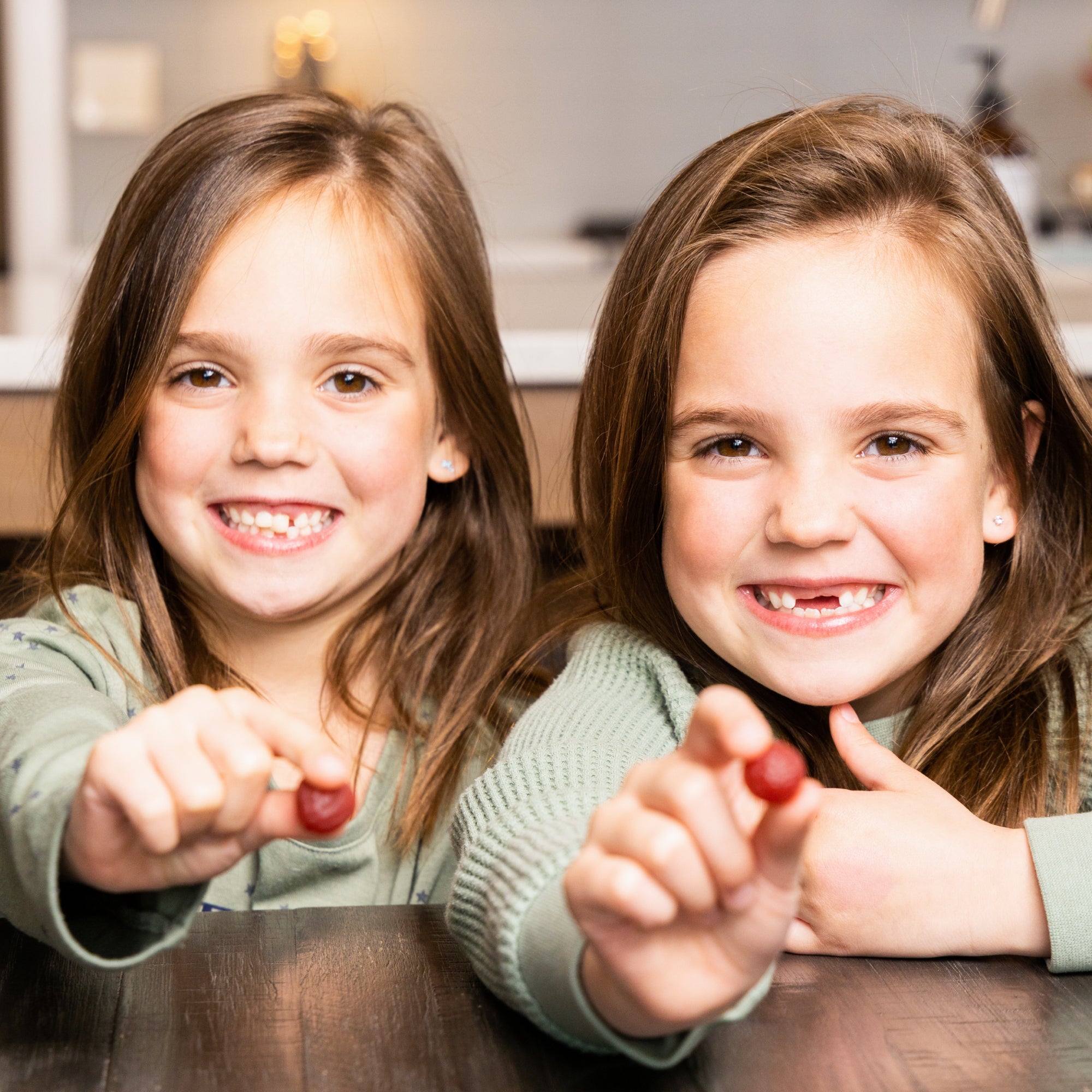 two young girls holding SBO Probiotics Kids Gummies