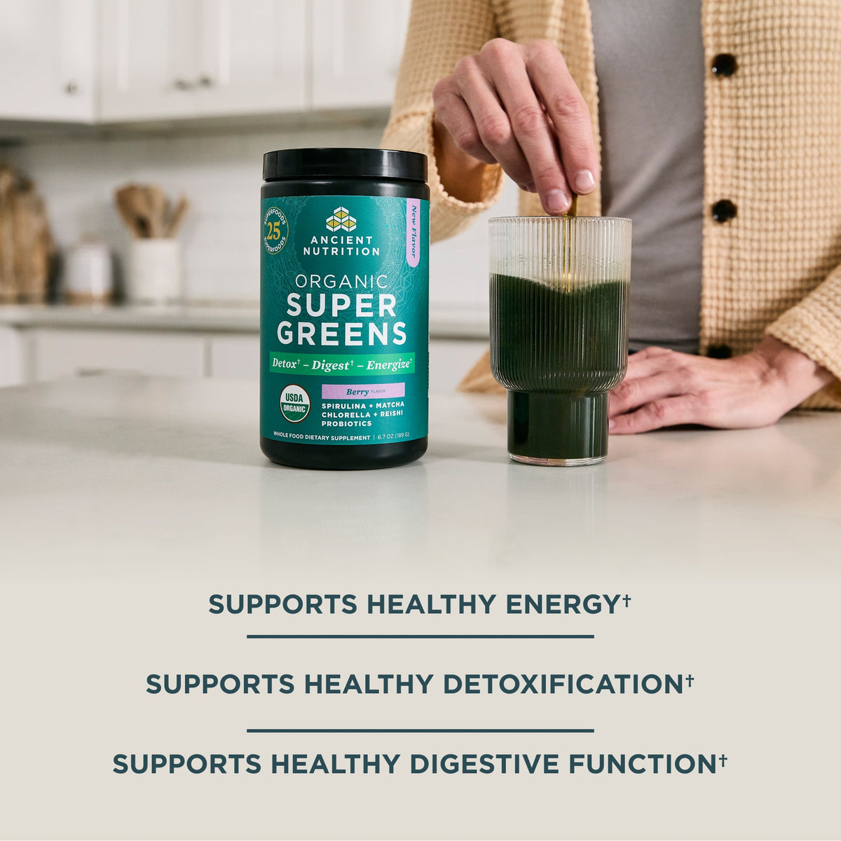 a bottle of Organic SuperGreens Powder Berry Flavor (25 Servings) next to a glass of green juice