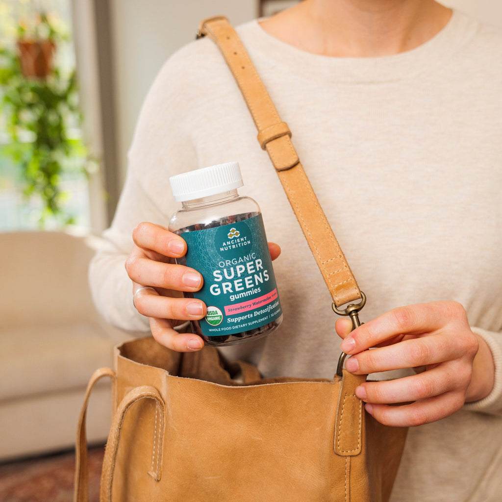 a woman taking Organic Super Greens Gummies Strawberry Watermelon Flavor our of her purse