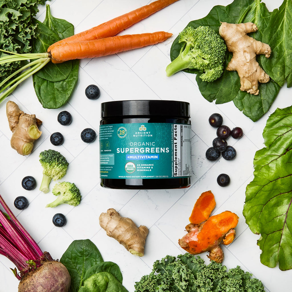 Organic SuperGreens + Multivitamin Powder (12 Servings) surrounded by fruits