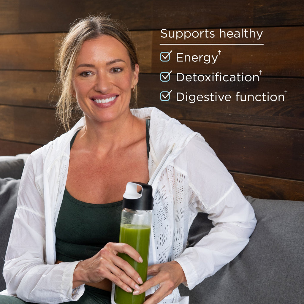 a woman holding a green juice bottle