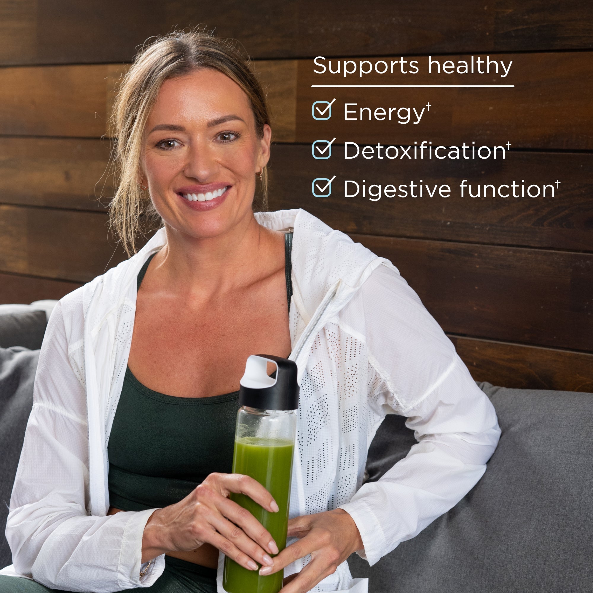 a woman holding a bottle of organic supergreens