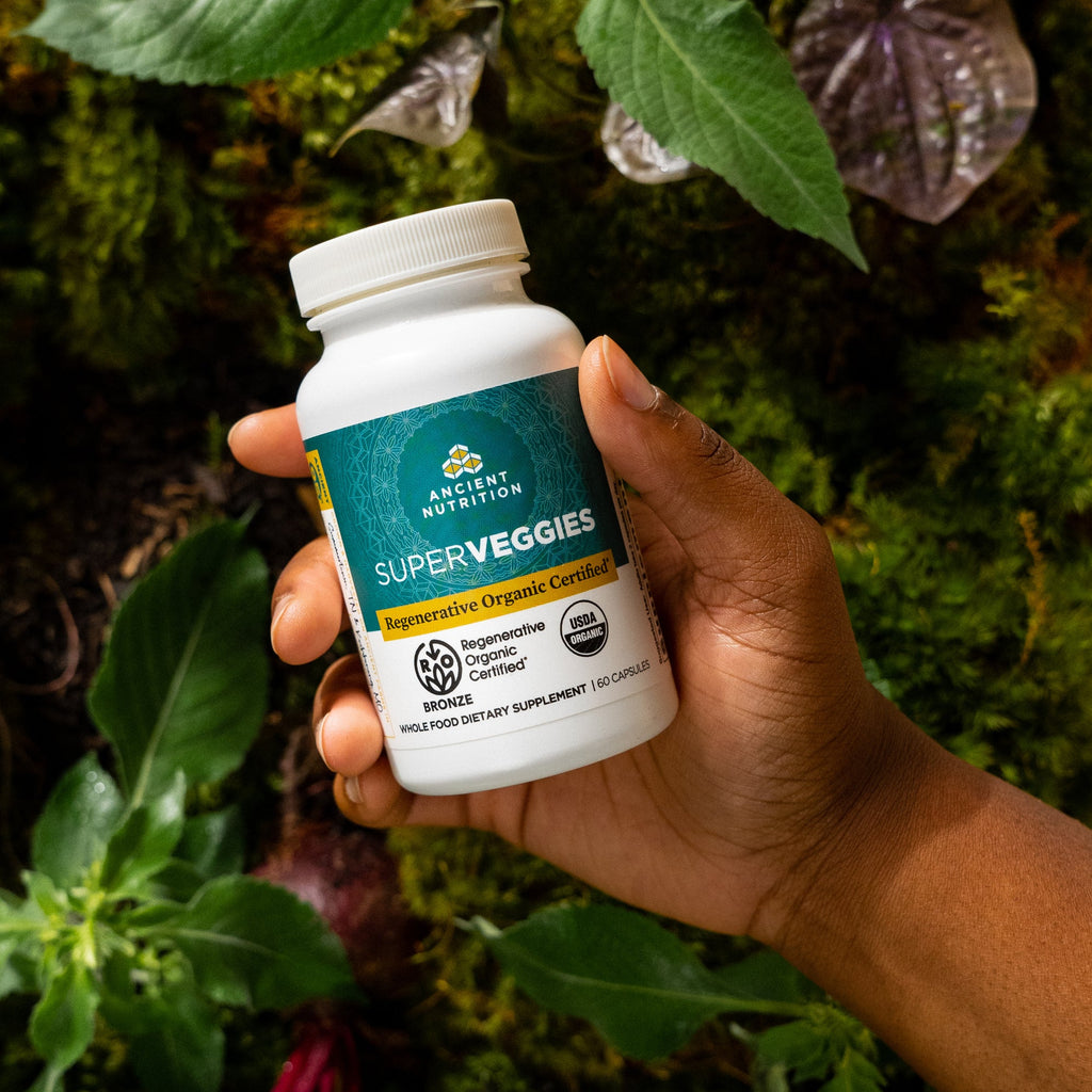 a person holding a bottle of Regenerative Organic Certifiedª SuperVeggies