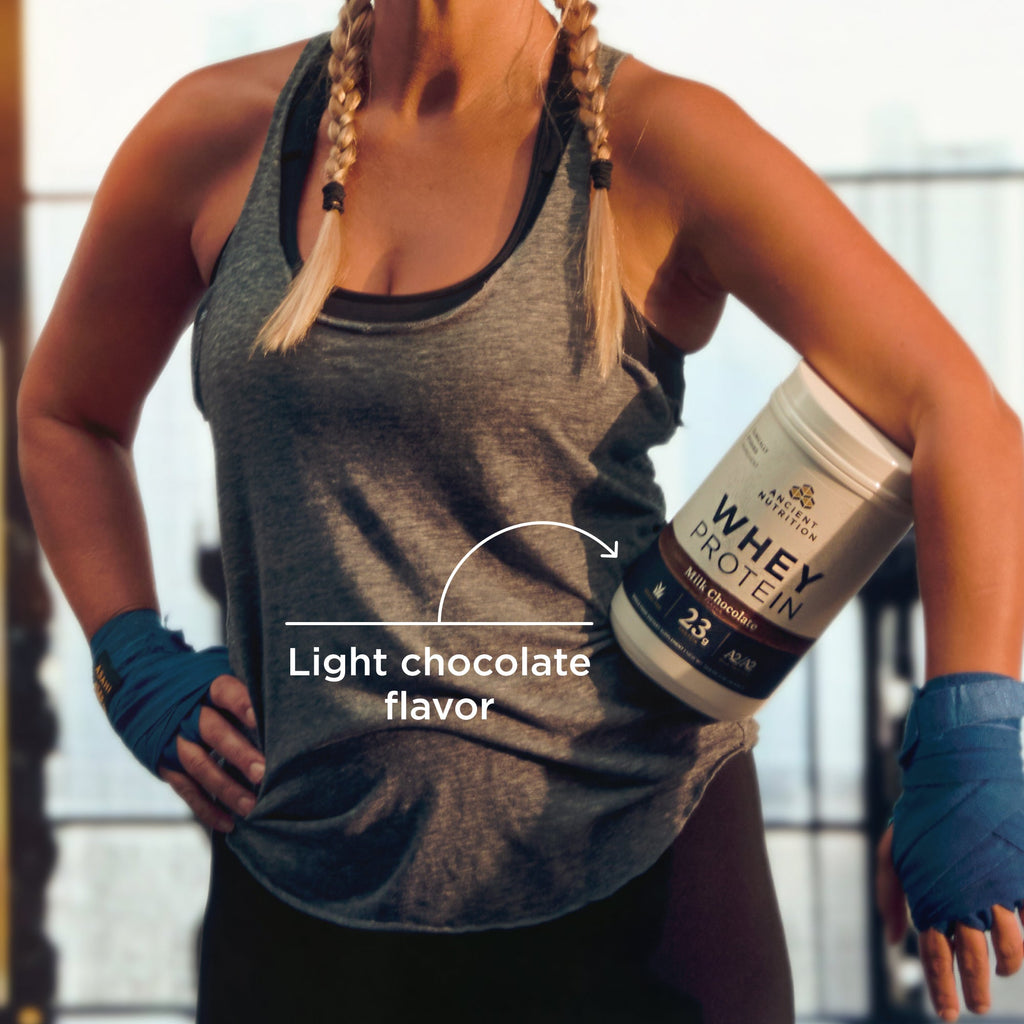 Woman in workout attire holding a container of whey protein with text indicating light chocolate flavor.