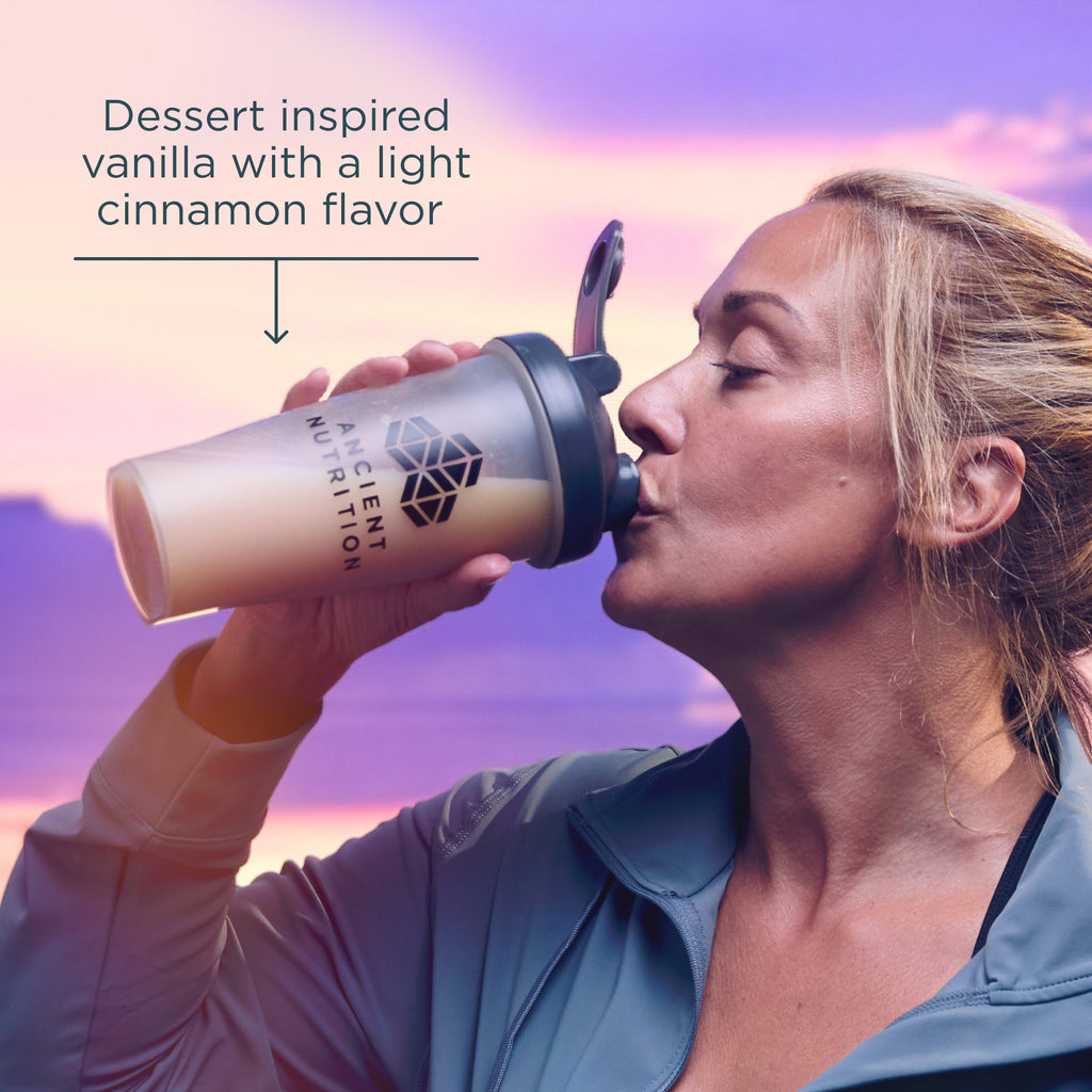 Woman drinking from a protein shaker with a sunset background