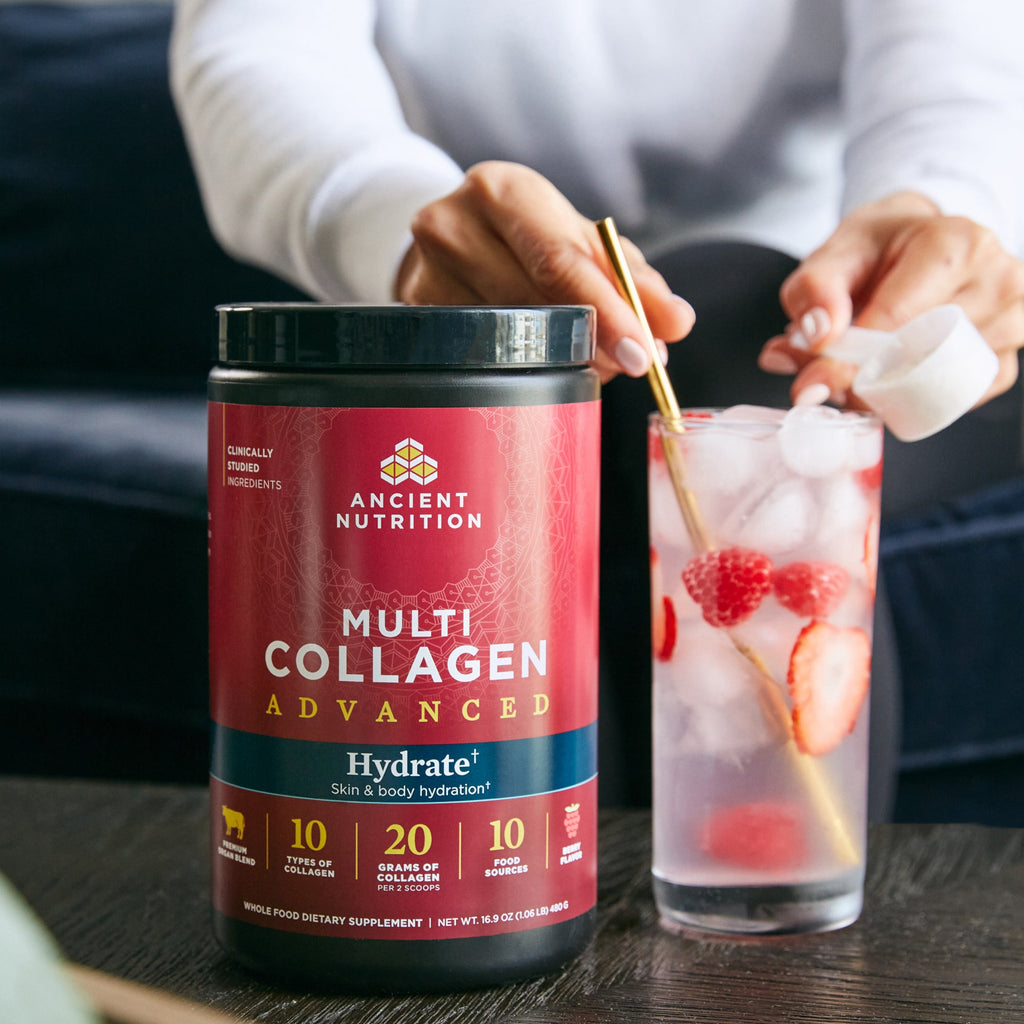 Multi Collagen Advanced Hydrate Powder Mixed Berry getting stirred into a glass of water